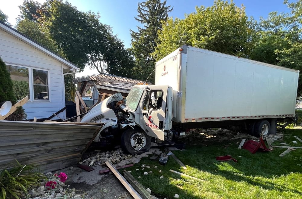 Truck crashes into fence, porch and shed, narrowly missing home post image