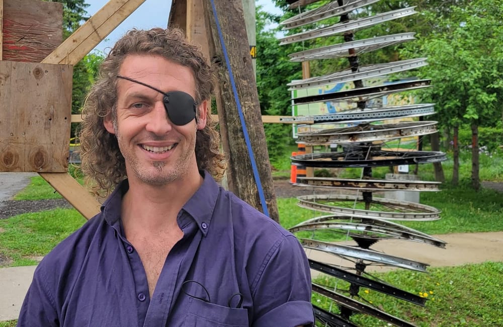 Local artist uses 101 bike rims to create sculpture arch post image