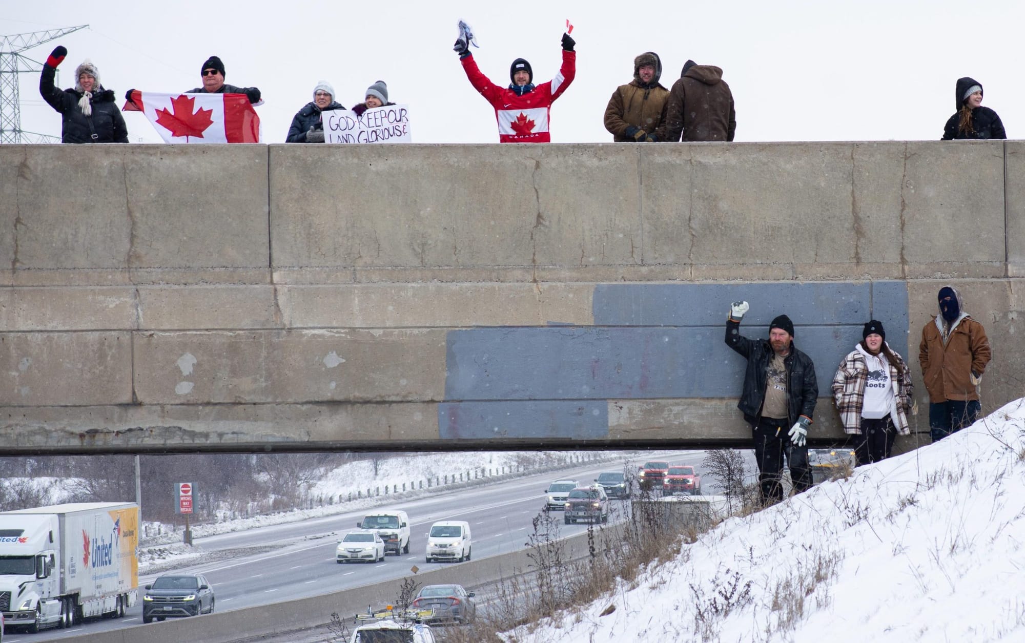 About 150 people gather on Highway 401 overpass to support truck convoy