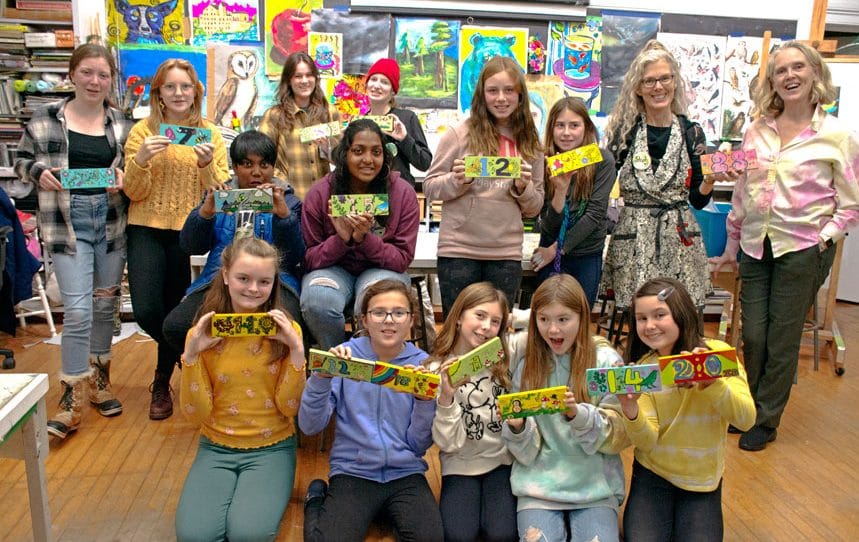 Youth group supports community garden with creative signs