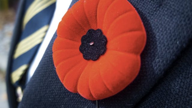 The iconic poppy pin is proudly worn in remembrance.